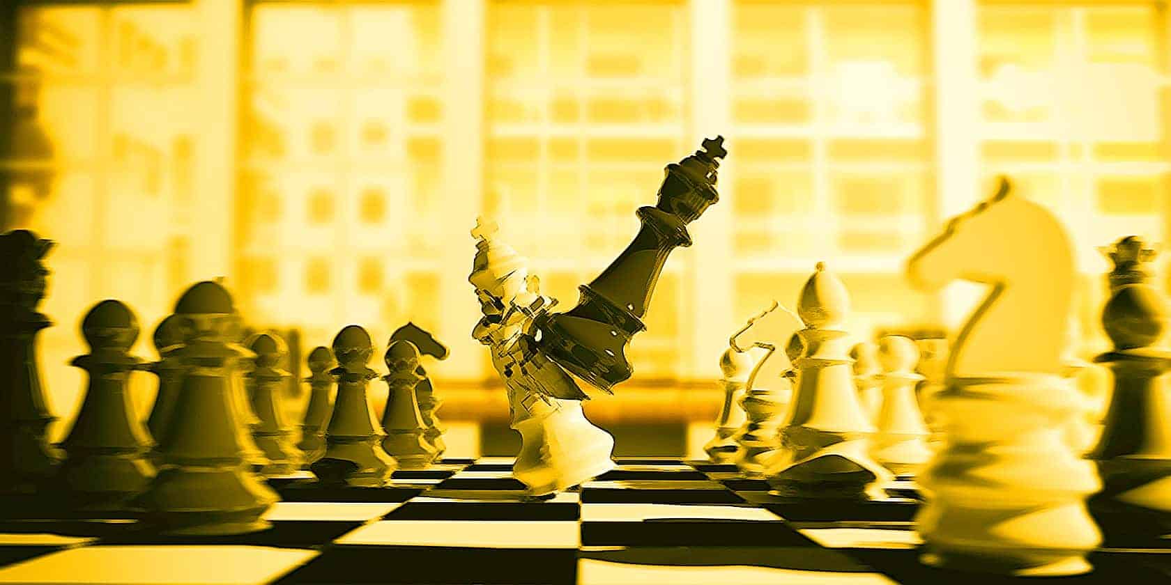 white chess king broken by the black king, on a chessboard, blur