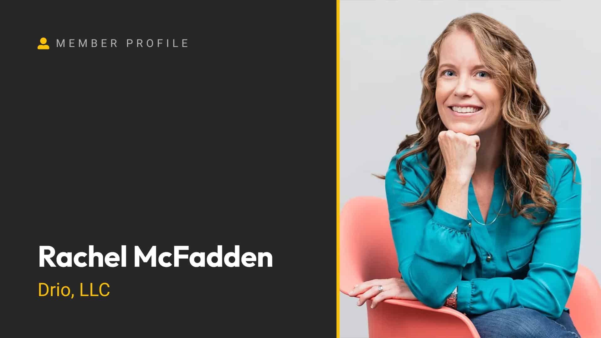 Rachel McFadden smiling with hand on chin, wearing a blue blouse, sitting on a pink chair.