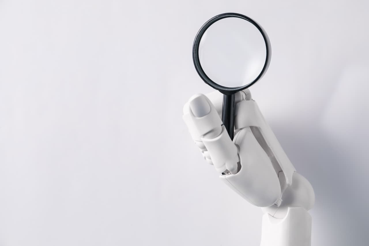 Robotic hand holding a magnifying glass, symbolizing AI and technology analysis.